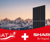Photovoltaik-Modul vor Bergkette, vorne die Logos von SAT Solar und Sharp.