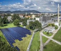 Luftbild der Solarthermieanlage am Heizwerk in Graz vor Stadtkulisse