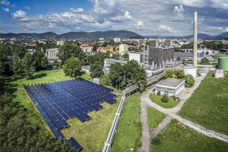 Luftbild der Solarthermieanlage am Heizwerk in Graz vor Stadtkulisse