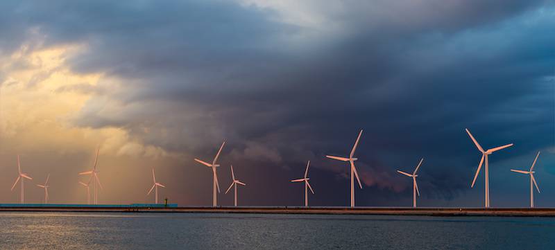 Offshore-Windkraft: Windkraftanlagen auf dem Meer vor dunklen Wolken