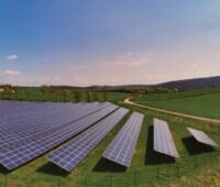 Eine freistehende Photovoltaik-Anlage auf einer Wiese in einer bayerischen Lanschaft.