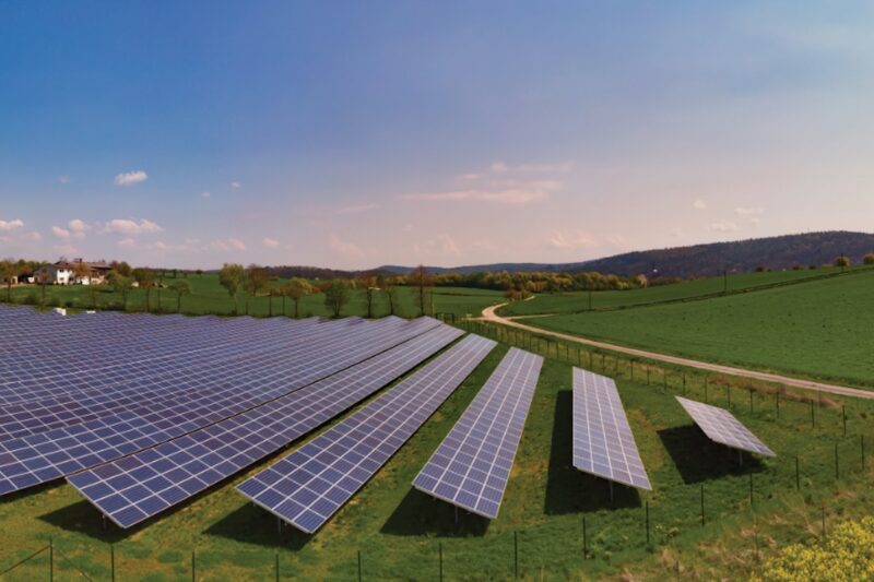 Eine freistehende Photovoltaik-Anlage auf einer Wiese in einer bayerischen Lanschaft.