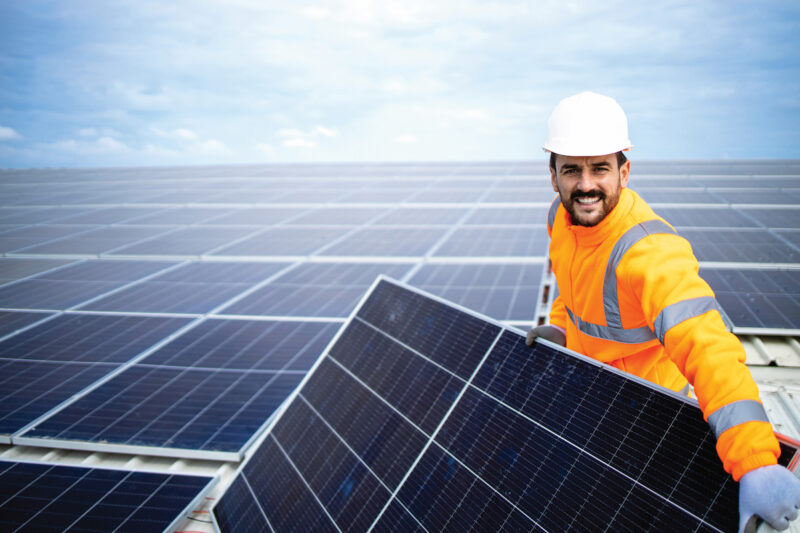 Ein Handwerker installiert ein Photovoltaikmodul für eine größere - gewerbliche - Anlage. Mieterstrom ist nun auch für das Gewerbe möglich.