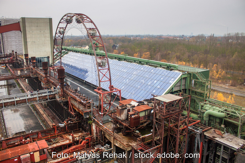 In der Mitte des Bildes eine große PV-Anlage. Sie befindet sich auf einer Industrieanlage der Zeche Zollverein.
