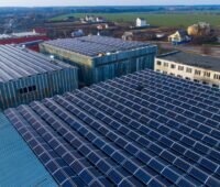 Luftbiild zeigt Gewerbehallendächer mit Photovoltaikmodulen.