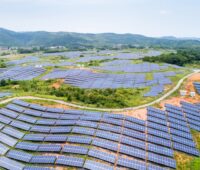 PV-Freiflächen über einer grünen Hügellandschaft in China.