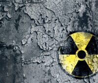 Das Zeichen für gefährliche Atomkraft auf schwarzem verwitterten Hintergrund.