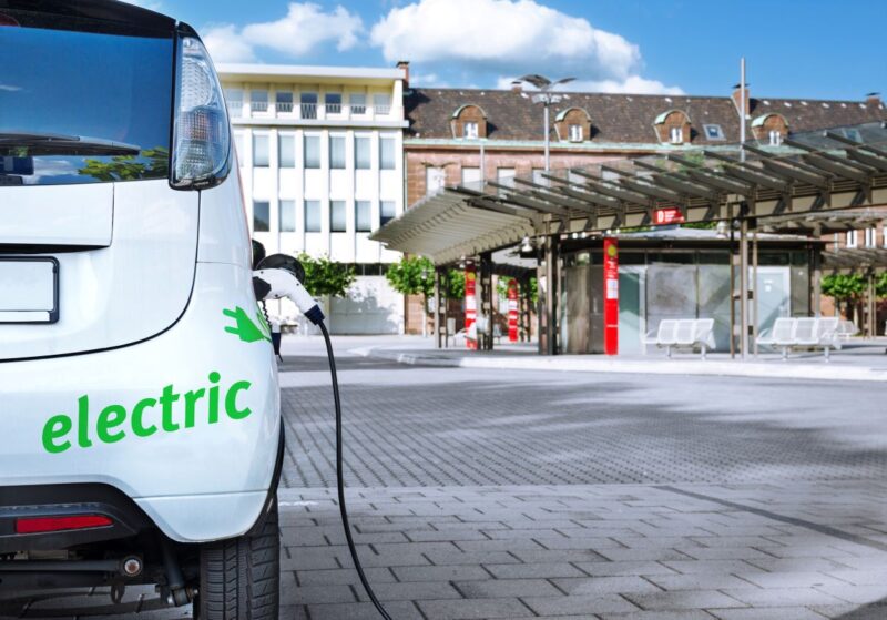 Ein Elektroauto auf einem städtischen Platz, das geladen wird.