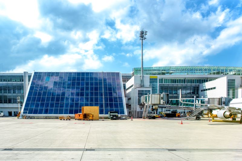 Flughafengebäude mit großflächiger Photovoltaik vom Rollfeld aus.