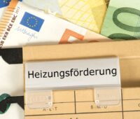 Hängemappe mit Aufschrift Heizungsförderung und Geldscheinen.