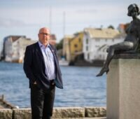 Mann mit Anzug vor Wasser neben Statue - Arvid Nesse vom Verband Offhore Norway aus Norwegen