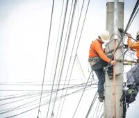 Im Bild zwei Männer auf einem Strommast, das Bundesministerium für Wirtschaft und Klimaschutz will mit der Novelle des Energiewirtschaftsrechts den Netzausbau beschleunigen.