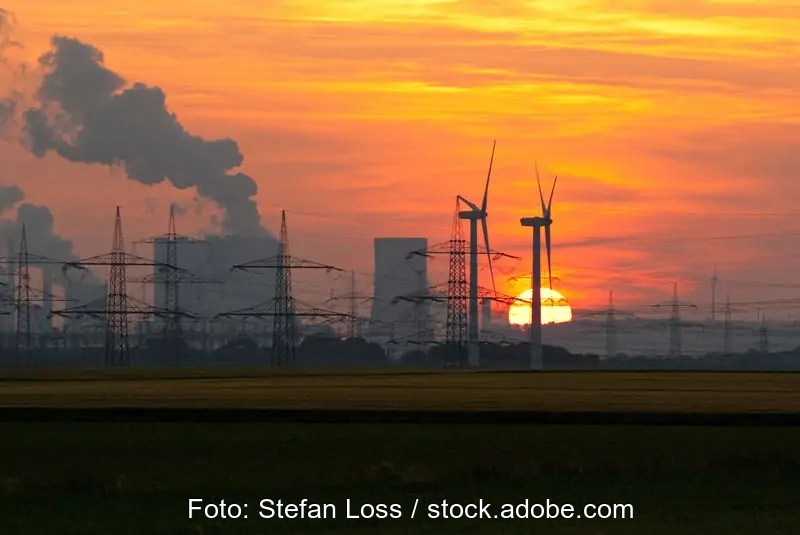 Zu sehen ist ein Kohlekraftwerk im romantischen Abendhimmel mit zwei verlorenen Windkraftanlagen im Vordergrund als Symbol für die handwerklichen Mängel im EEG 2021