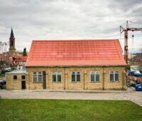 Rot eingefärbte Solarmodule, integriert in ein rotes Dach eines historischen Gebäudes in Eppingen.