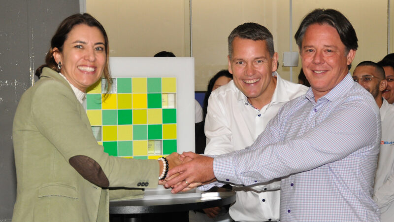 Zwei Männer und eine Frau schütteln sich die Hände - Übernahme von Ribeiro Solar in Brasilien durch Baywa r.e.