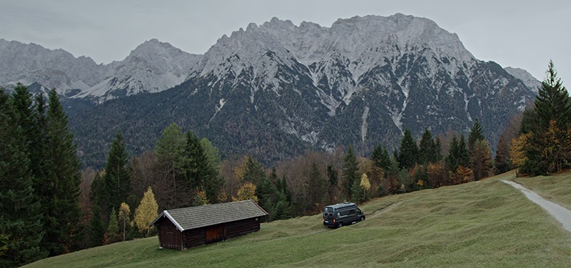 Im Bild eine Hütte vor Bergen, in der ein stationäres Brennstoffzellen Gerät von SFC Energy zum Einsatz kommt.