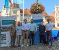 Gruppenfoto auf einem Marktplatz - Energiequelle und Enertrag gründen Grünstrom Lausitz