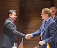 Zwei Männer im Anzug schütteln Hände - Kooperation für die Integration indischer Fächkräfte in die Deutsche Solarbranche