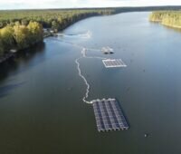 Luftbild von See, drei schwimmende Inseln aus Floating PV Systemen.