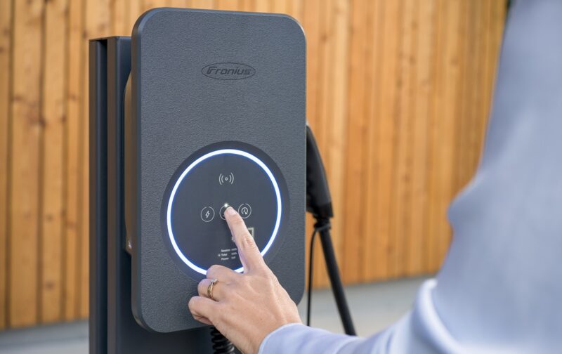 Der Fronius Wattpilot Flex wird direkt über Touchbuttons oder via App per Smartphone und Eine Hand bedient den Fronius Wattpilot Flex.