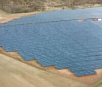 Luftbild eines Freiflächensolarparks auf trockenem Boden.