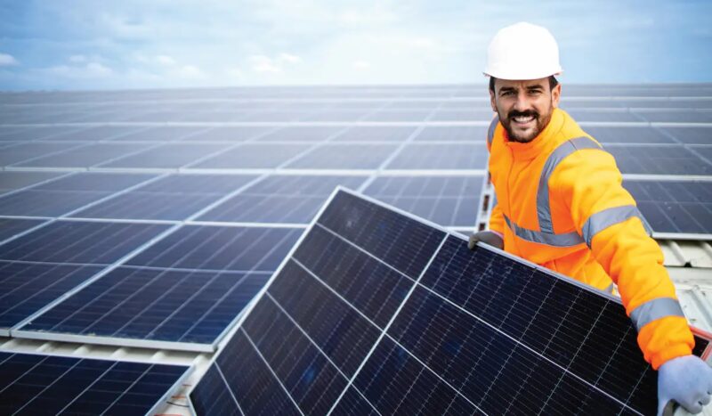 Im Bild ein Handwerker, der ein PV-Modul installiert, der Solar Module Quality Standard SMQS soll langfristige Energieerträge der Solaranlagen sicherstellen.