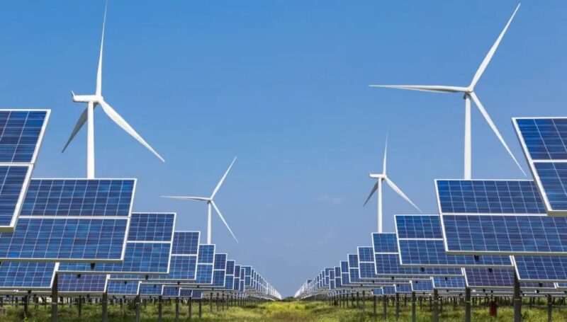 Zu sehen sind Windenergieanlagen und Photovoltaik-Module als Symbol für das Grüner-Strom-Label.
