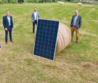 Zu sehen ist das Team von Highfield Solar auf einem Acker mit Photovoltaik-Modul.