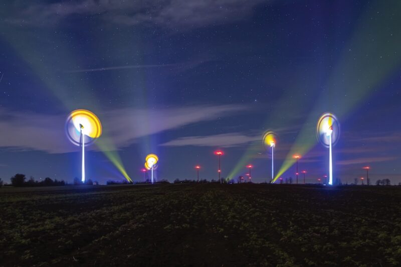 Kunst: Leuchten an Windenergieanlagen zeichnen bunte Bilder in den Nachhimmel.