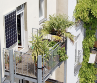 Grüner Balkon mit Mini-PV-Gerät an der hauswand