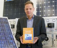Zu sehen ist Prof. Dr. Konrad Mertens mit seinem Photovoltaik-Lehrbuch.