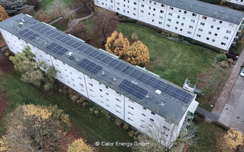 Luftbild zeigt Mietskasernen mit PV auf den Dächern.