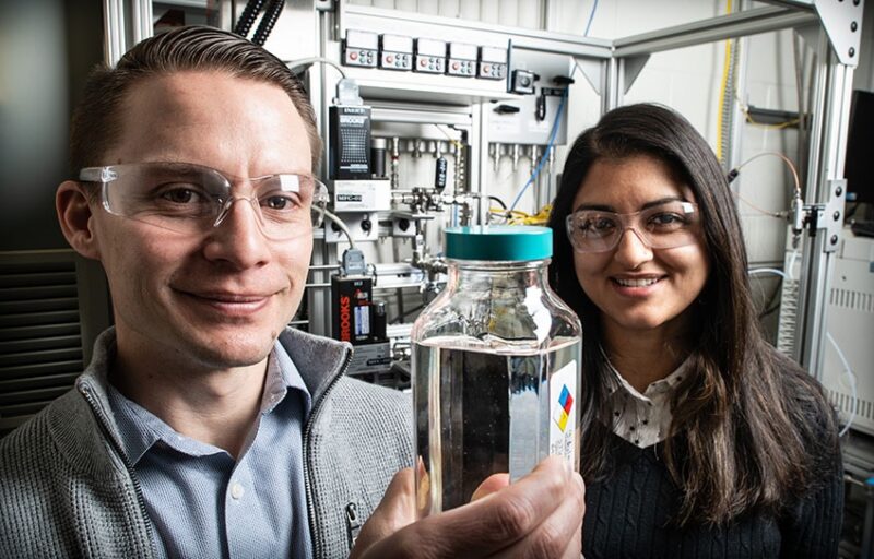 Die Forscher Derek Vardon und Nabila Huq zeigen eine Behälter mit dem Biokraftstoff.