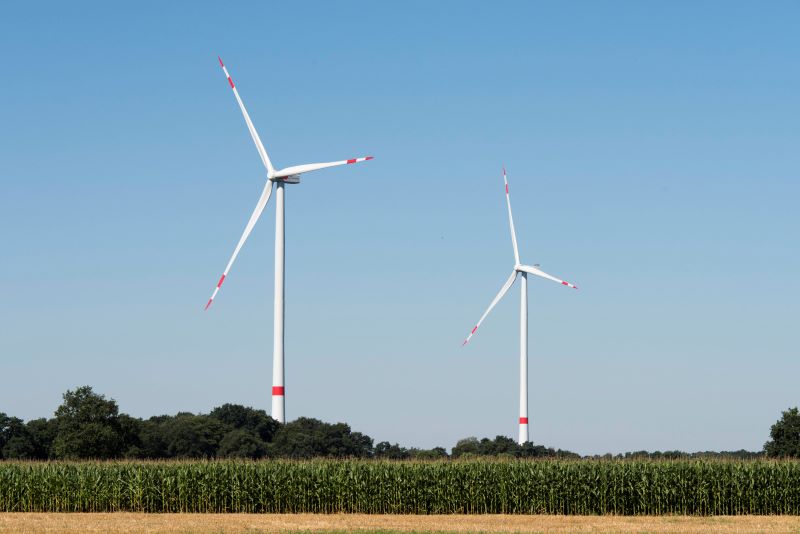 Zwei Windenergieanlagen in einer ländlichen Umgebung.
