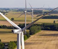 Luftaufnahme zeigt mehrere Nordex 2,4 MW Windenergieanlagen von Nordex zwischen Feldern und Bäumen