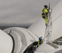 Im Bild Männer auf Windturbine, der Hersteller Nordex hat im Geschäftsjahr 2025 Gewinn erzielt.