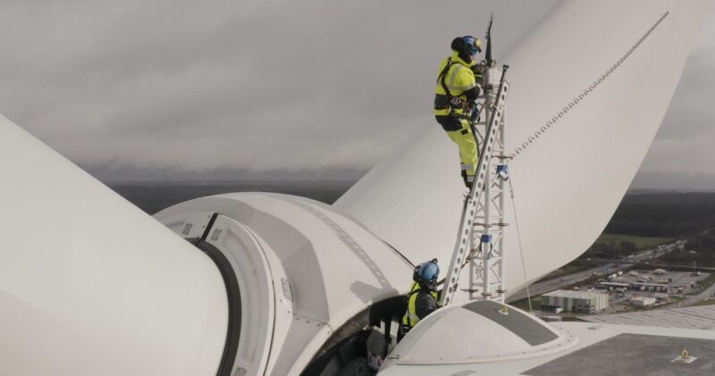 Im Bild Männer auf Windturbine, der Hersteller Nordex hat im Geschäftsjahr 2025 Gewinn erzielt.