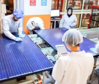 Wissenschaftlerinnen udn Wissenschaftler prüfen eine Anlage mit Solarmodulen.