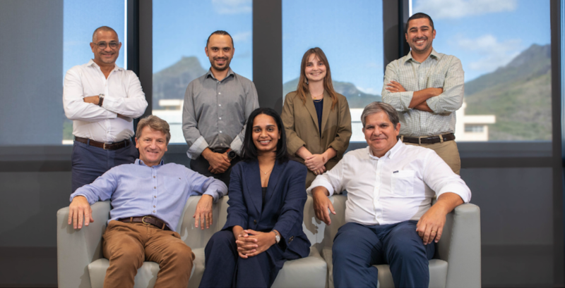 Gruppenbild mit zwei Frauen und fünf Männern um ein Sofa, im Hintergrund Berge. Startschuss für PV-Recycling-Projekt in Mauritius