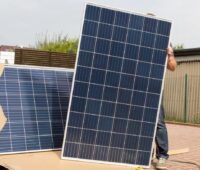 Im Bild ein Mensch der Solarmodule aus einem Karton auspackt, wie sie der neue Photovoltaik-Großhändler Quantumsolarpv liefern könnte.
