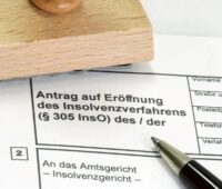 Im Bild ein Stempel und ein Formular zur Eröffnung von einem Insolvenzverfahren, in dem sich PV-Projektierer Fellensiek befindet.