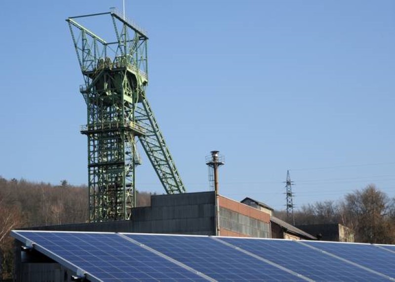 Vor einem Förderturm für Kohle ist ein Solardach installiert