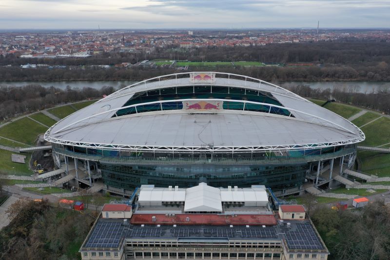 Das Stadion in Leipzig aus der Luft. Im Vordergrund ein gründerzeitliches Gebäude mit Solarpaneelen auf dem Dach.