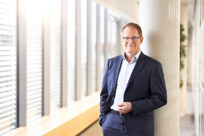 Mann im Anzug vor Fensterfront - SMA-Vorstandsvorsitzender Jürgen Reinert