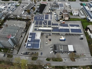 Zu sehen ist die größte Photovoltaik-Anlage Tübingens in einer Luftaufnahme, die die auf unterschiedliche Dächer verteilte Anlage zeigt.