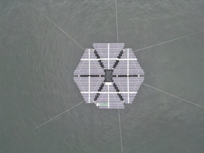 sechs Dreiecke, bestückt mit PV-Modulen, schwimmen auf Meer - Offshore-Solaranlage