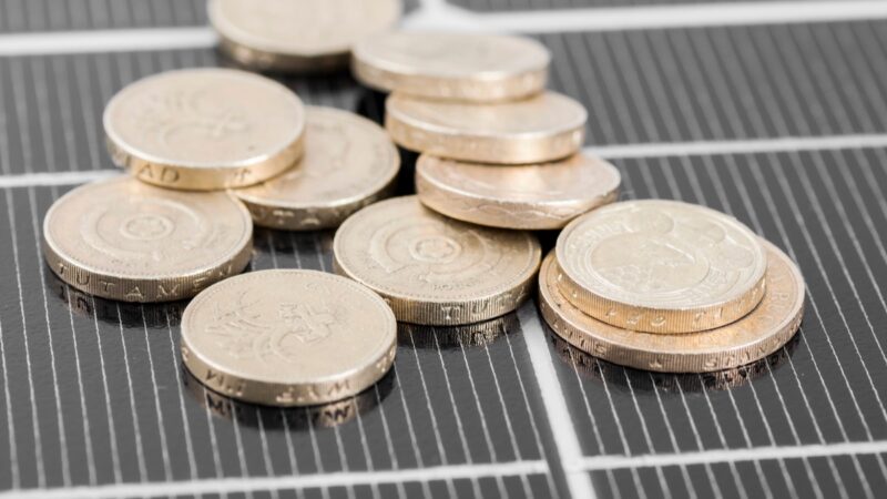 Münzen auf Photovoltaik-Module - Symbol für Förderung von Photovoltaik bei progres.nrw