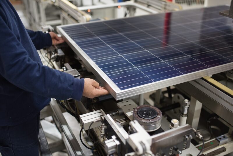 Photovoltaik-Modul in Fertigung, zwei Hände - Symbolbild für Verbot von Zwangsarbeit