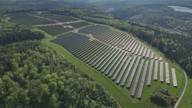 Luftbild eines Solarkomplexes umgeben von Wald.