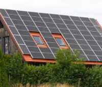 Im Bild ein Haus mit einer Photovoltaik-Anlage, die eine Förderung in Form der Einspeisevergütung erhalten kann.